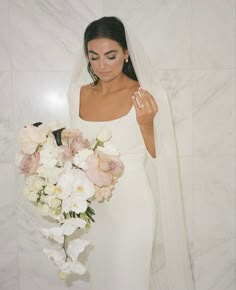 a woman in a wedding dress holding a bouquet of flowers