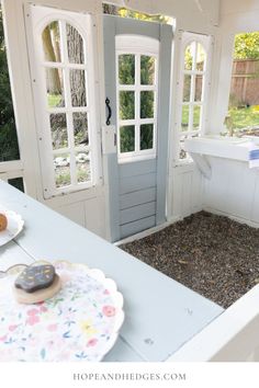 an outdoor kitchen with white walls and wooden doors, decorated in pastel blue tones