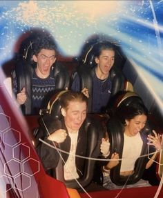 several people are riding on roller coasters at an amusement park