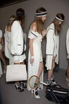 several models in white outfits with tennis rackets