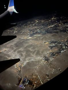 the wing of an airplane flying over a city at night