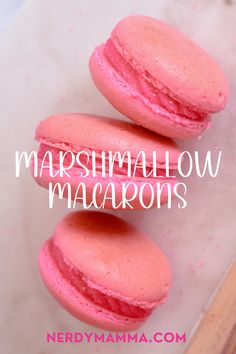 three pink macarons sitting on top of each other with the words marshmallow macaroons above them