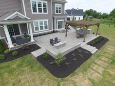 an aerial view of a backyard with patio and pergolated area in the foreground