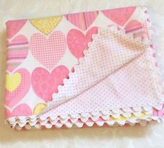 a pink and yellow heart patterned cloth with ruffles on it's edge