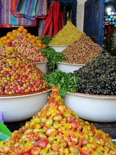 bowls filled with different types of fruits and vegetables on display in front of a store