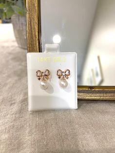 14k white, yellow or rose gold bow earring with a hanging cultured pearl. 1mm cz in the center of the bow. Earring Size 10mmX13mm, 6mm Pearl All photos are natural and have been taken to the best of our ability. ❤ We guarantee that the item is identical as the actual photo seen. ❤ We Guarantee 100% Pure 14K Gold ❤ Please feel free to message us with any questions you may have ❤ All our Items are Allergy free Thank You, ❤ Mushky S Elegant Rose Gold Earrings With Bow, Elegant Rose Gold Bow Earrings, White Bow Earrings For Anniversary, Formal Rose Gold Jewelry With Bow, Formal Rose Gold Bow Jewelry, Elegant 14k Gold Jewelry With Bow Detail, Elegant 14k Gold Jewelry With Bow, White Bow Jewelry For Anniversary, Bow Earring