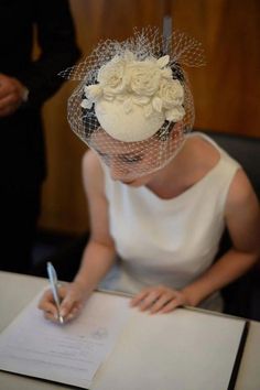 a woman sitting at a table with a pen in her hand