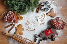 some cookies are laying out in the snow and on top of a wooden table next to a christmas tree