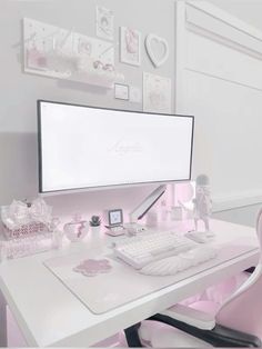 a white desk topped with a computer monitor next to a pink chair and other items