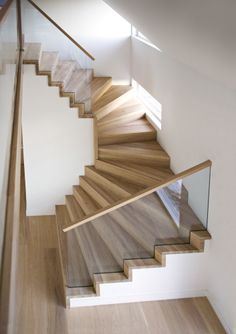 a wooden stair case with glass balustncing