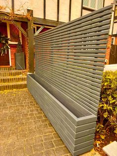 a grey bench sitting on top of a brick walkway