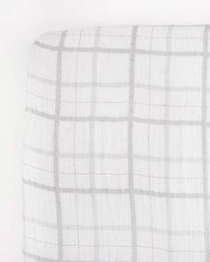 a white and grey checkered blanket on top of a bed