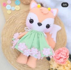 a small stuffed animal is sitting on a basket with flowers and buttons in it's mouth