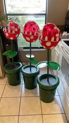 four plastic flower pots sitting in front of a window