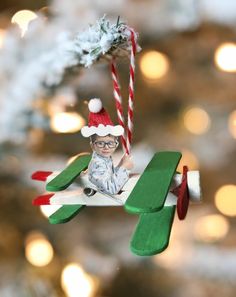 an ornament hanging from a christmas tree with a toy airplane and candy cane