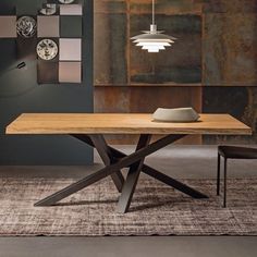 a wooden table sitting on top of a rug next to a wall mounted light fixture