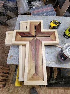 a wooden cross sitting on top of a table next to other woodworking tools and supplies