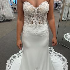 a woman in a white wedding dress looking at her reflection