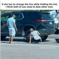 two men are trying to change the tire while another man is on the side of the road