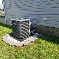 an air conditioner sitting in the grass next to a house