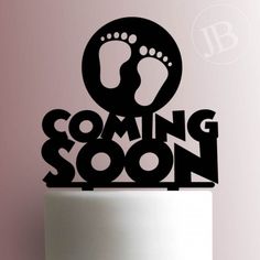 a cake topper with the words coming soon on it and feet sticking out of it