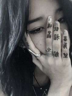 a woman holding her hands to her face with chinese writing on the side of her fingers