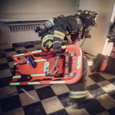 a fireman's gear is sitting on top of a checkerboard floor