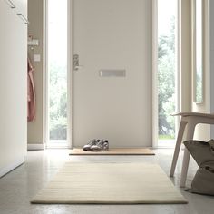 a pair of shoes sitting on top of a rug in front of a white door