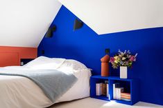 a bedroom with blue walls and white bedding