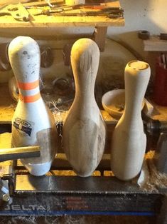 several wooden bowling pins and bowls on a work bench