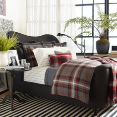 a living room filled with lots of furniture and pillows on top of a striped rug