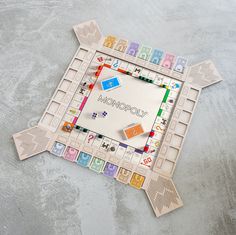 a monopoly board game laying on top of a cement floor with the word monopoly written in it