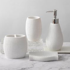 white bathroom accessories set on marble counter top