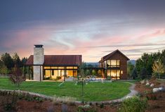 the house is surrounded by green grass and trees