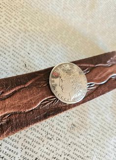 "This is a handmade One of a Kind leather bracelet that fits a wrist size of 7.75\". It is made from a vintage piece of leather that is a medium brown with gorgeous tooled pattern. 1.2\" wide.  The centerpiece is a silver plated metal Concho that is a Morgan dollar coin shape. These are very well done molds and look like real coins. There is a stainless steel snap closure.  You can use my leather cuffs for aromatherapy as well by adding a few drops of your favorite essential oil to the back of the leather when wearing." Recycled Bracelets, Aromatherapy Bracelet, Morgan Dollars, Dollar Coin, Tooled Leather, Well Done, Leather Cuffs, Medium Brown, Leather Tooling