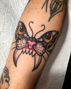 a close up of a person's arm with a cat tattoo on it,