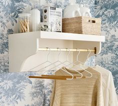 a white shelf with some clothes hanging on it