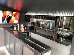 a bar with black granite counter tops and white cabinetry is featured in this image