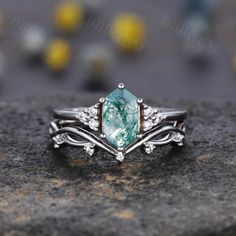 a close up view of a ring with an aqua green stone and white diamonds on it