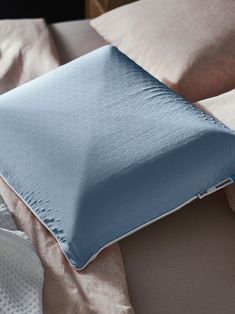 a blue pillow sitting on top of a bed