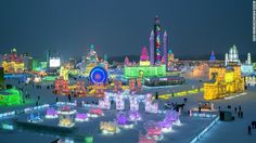 an aerial view of the ice and snow covered city at night, with brightly lit buildings in the background