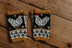 two knitted mittens sitting on top of a wooden floor