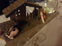 a birdhouse made out of hay and other items sitting on a dining room table