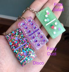 two small pieces of plastic with different colors and designs on them are being held in someone's hand