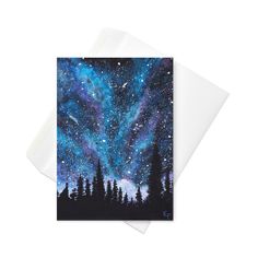 a greeting card with the night sky and stars above trees in the foreground, on top of a white envelope