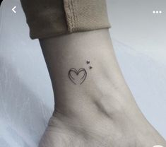 a small heart tattoo on the ankle