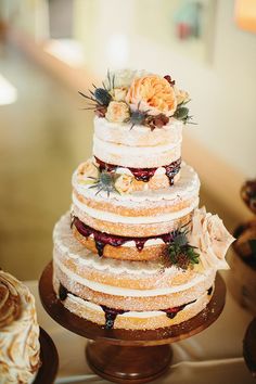 a three tiered wedding cake with flowers on top