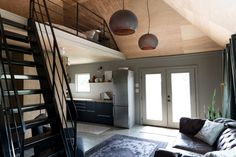 a living room filled with furniture and a spiral staircase leading up to the top floor