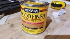 a can of wood finish sitting on top of a wooden table next to some tools