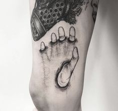 a black and white drawing of a hand holding a baby's foot with the word,